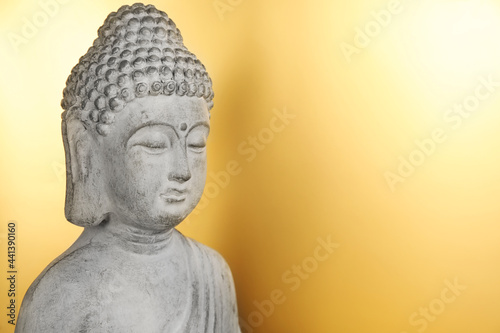 Buddha statue on golden background, closeup. Space for text