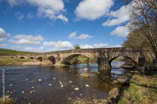 Large stone bridge crossing the river ribble near Clitheroe. Edisford bridge with rocks in the foreground 