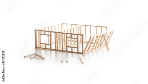 Building a house or a home. Frame work of a house (miniature model) isolated on white with natural shadows.
