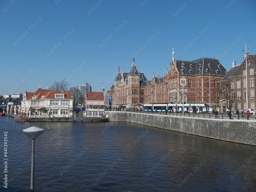 Blick über das Wasser auf den Hauptbahnhof von Amsterdam, Niederlande Blick über das Wasser auf den Hauptbahnhof von Amsterdam, Niederlande