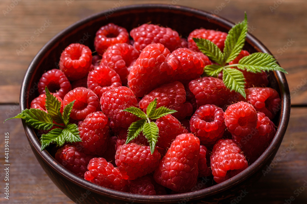 Delicious fresh juicy red raspberries on a dark table Delicious fresh juicy red raspberries on a dark table