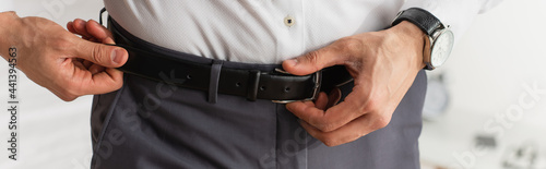 Cropped view of businessman wearing waist belt, banner © LIGHTFIELD STUDIOS