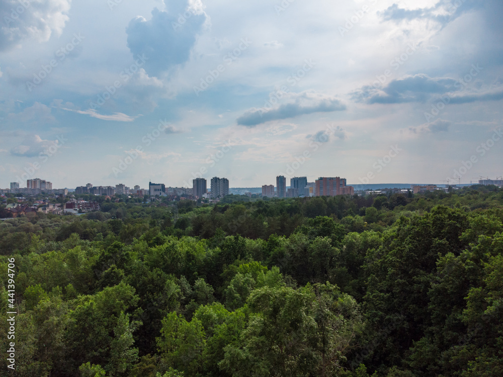 Aerial view on green summer Kharkiv city center Sarzhyn Yar park. Botanical garden with high trees and scenic cloudscape in residential area