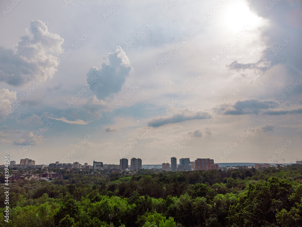 Aerial sky view on green summer Kharkiv city center Sarzhyn Yar park. Botanical garden with high trees and scenic cloudscape in residential area
