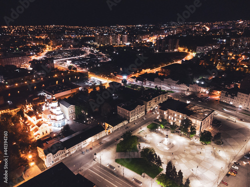 Night lights illuminated city aerial view. City center square (Maidan Konstytutsii) with historical museum, Svyato-Pokrovskyy Monastyr landmarks in Kharkiv, Ukraine photo