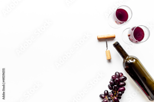 Red wine bottle with corkscrew and glasses. Top view