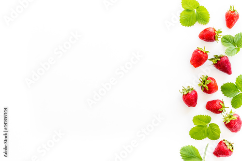 Group of ripe strawberries with green leaves. Flat lay