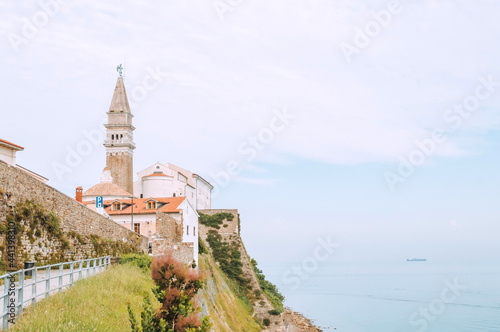 Sunny summer view of St. George's Parish Church in Piran town. Beautiful cityscape of Slovenia, Europe. Traveling concept background.