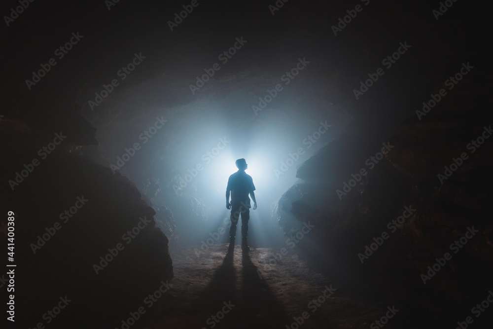 Unrecognizable man standing in narrow cave Unrecognizable man standing in narrow cave