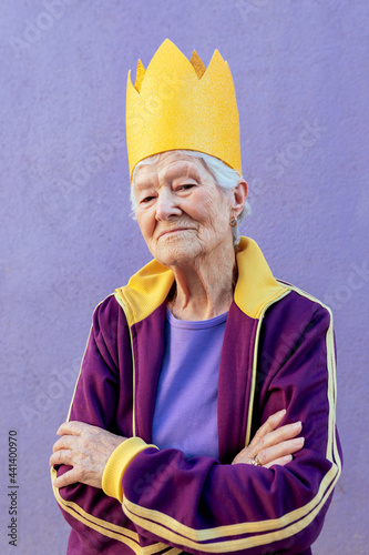 Senior sportswoman in paper crown with crossed arms