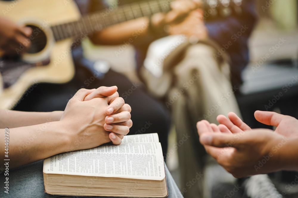 Christian family groups holding hands praying with Holy Bible. and play  guitar to sing worship thanksgiving praise and seek the blessings of God  with belief. reading Bible and sharing the gospel Stock