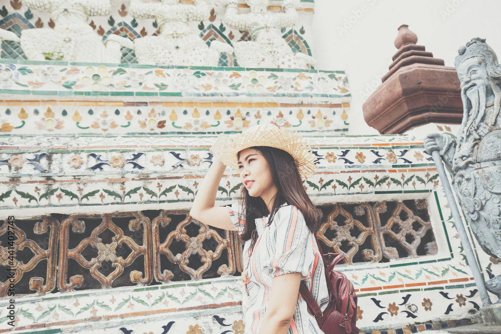 Fototapeta premium Asian backpacker women wear sun hat traverl in temple of buddha