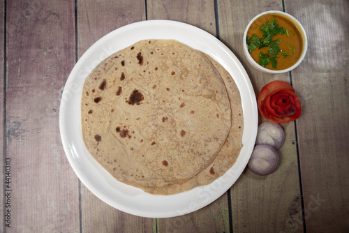 Round indian bread chapati on a white plate