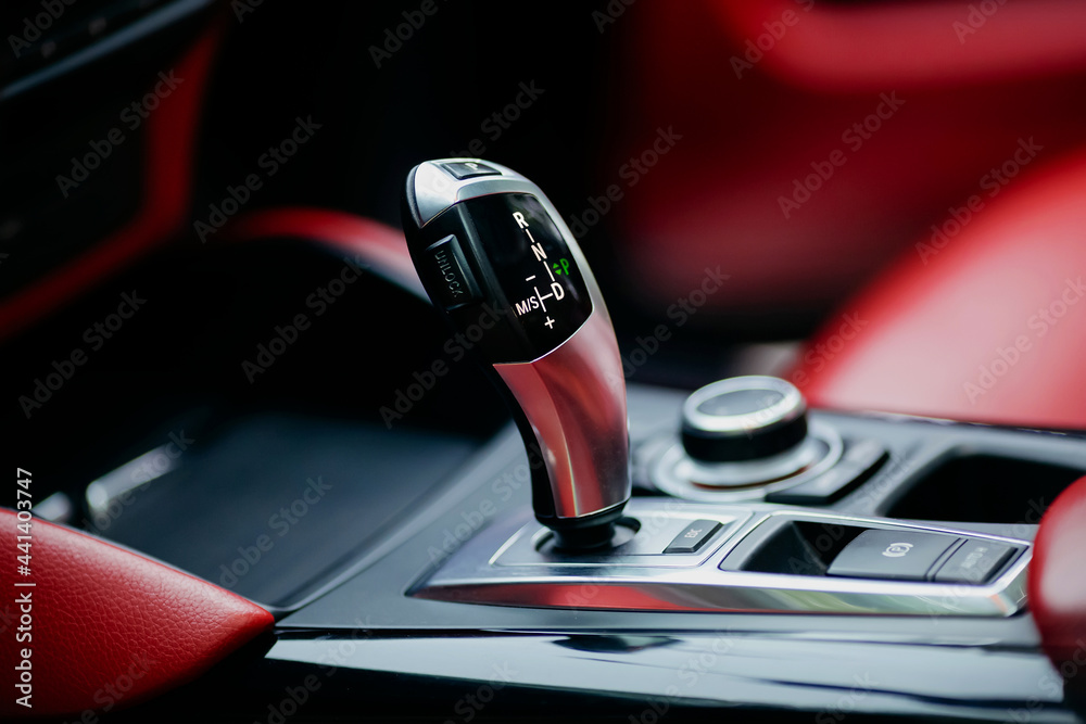 Obraz premium Automatic gear stick of a modern car. Modern car red interior details. Close up view.