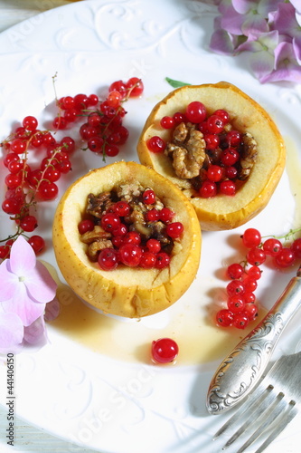 Baked apples with honey, walnuts, currants on a white background