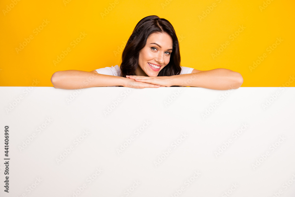 Photo of shiny pretty young woman wear white t-shirt lying big white wall empty space isolated yellow color background Photo of shiny pretty young woman wear white t-shirt lying big white wall empty space isolated yellow color background