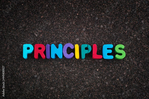The word Principles on a dark cork board