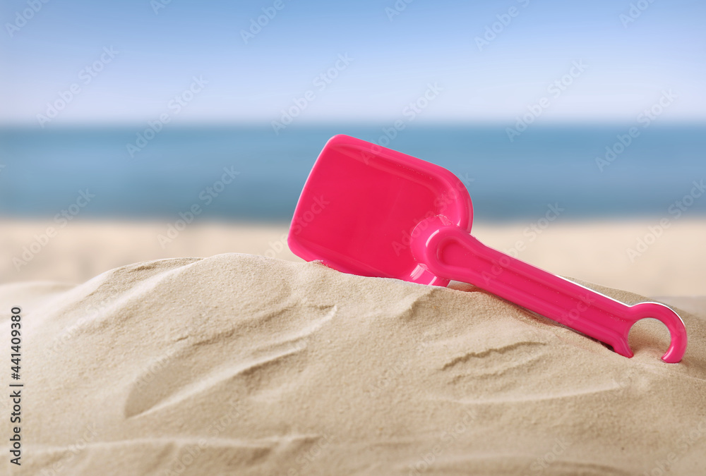 Pink plastic toy shovel sandy beach near sea Pink plastic toy shovel sandy beach near sea
