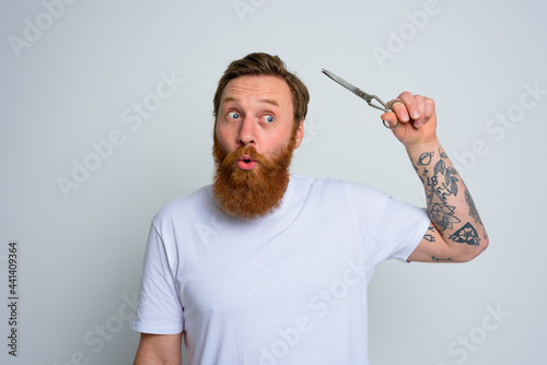 Wondered man with scissors is ready to cut the beard