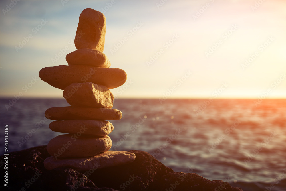 Wall Mural Zen stones on a ocean sea cliff in sunset sunrise time.