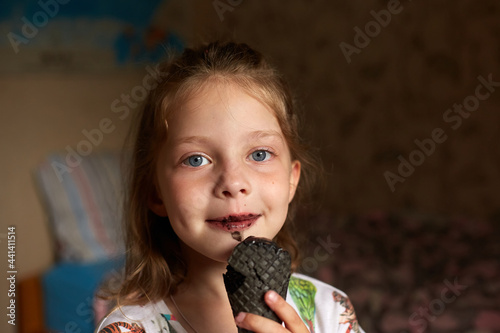 a little girl eats black ice cream, her mouth and teeth are black