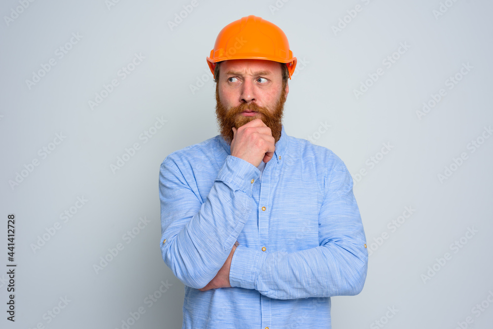 Isolated doubter architect with beard and orange helmet Isolated doubter architect with beard and orange helmet