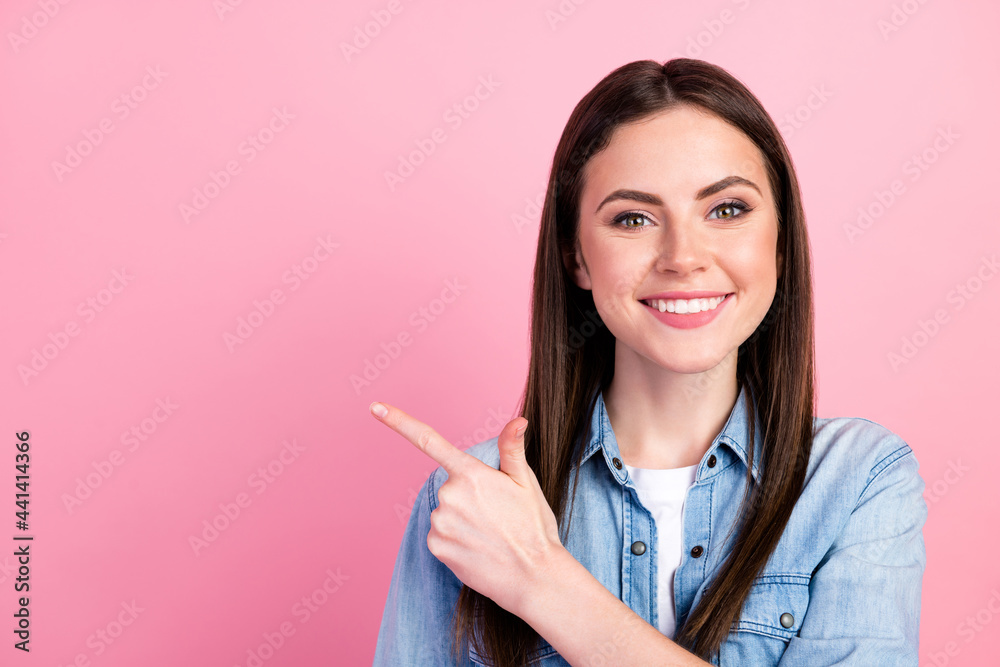 Photo portrait of female student pointing finger empty space recommending isolated on pastel pink color background Photo portrait of female student pointing finger empty space recommending isolated on pastel pink color background