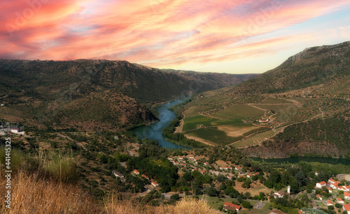 beautiful sunset from the top of the viewpoint of El Salto located in the Arribes del Duero with the river flowing through the mountains and the village in the background. photo