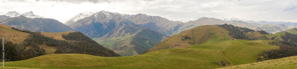 Aktoprak is a pass, known since ancient times, connecting the Baksan and Chegem gorges. Panorama view of green hills covered with vegetation and high mountains. Kabardino-Balkaria, Russia