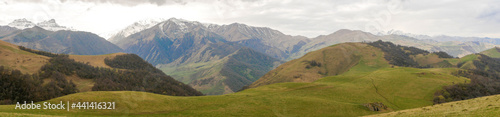 Aktoprak is a pass, known since ancient times, connecting the Baksan and Chegem gorges. Panorama view of green hills covered with vegetation and high mountains. Kabardino-Balkaria, Russia