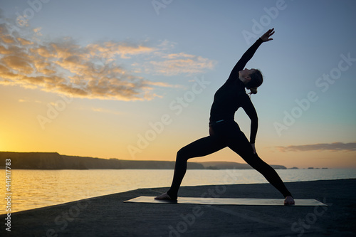 posture of a woman's yoga in silhouette at sunset