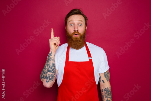 Fototapeta amazed isolated chef with beard and red apron