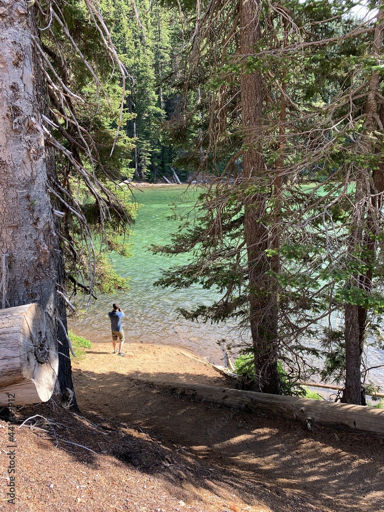 Young adult skips a rock across the gorgeous emerald green Devil's Lake in Oregon Young adult skips a rock across the gorgeous emerald green Devil's Lake in Oregon