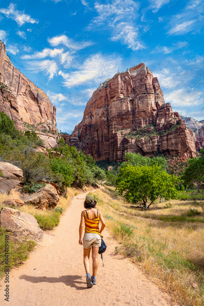 A young woman starting the trekking climb of the Angels Landing Trail in Zion National Park, Utah. United States, vertical photography
