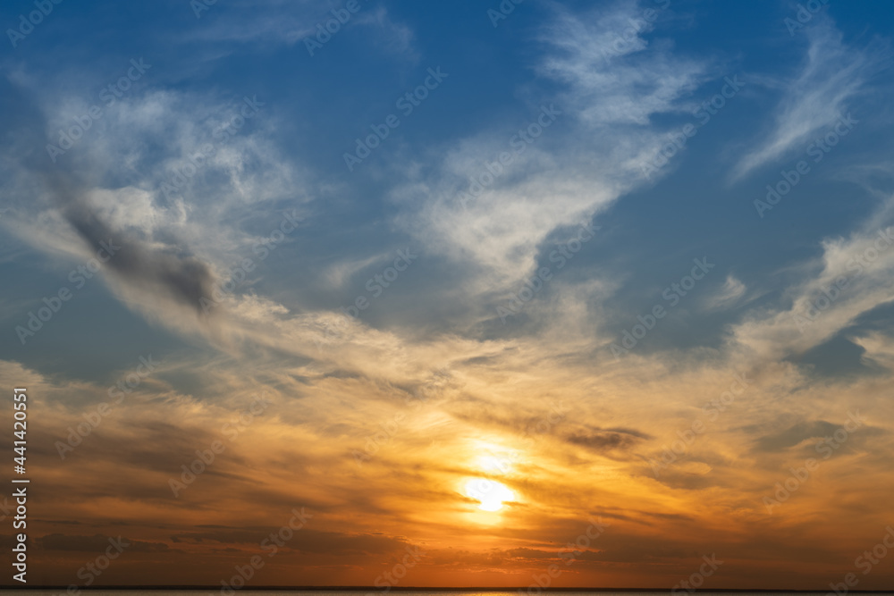 Fototapeta premium Calm on the coast. The sky in the evening. Water. Sunset sky on the coast. Golden hour. Sky and clouds. Feather cloud. The sun went down below the horizon. Evening sky background. Sunrise landscape