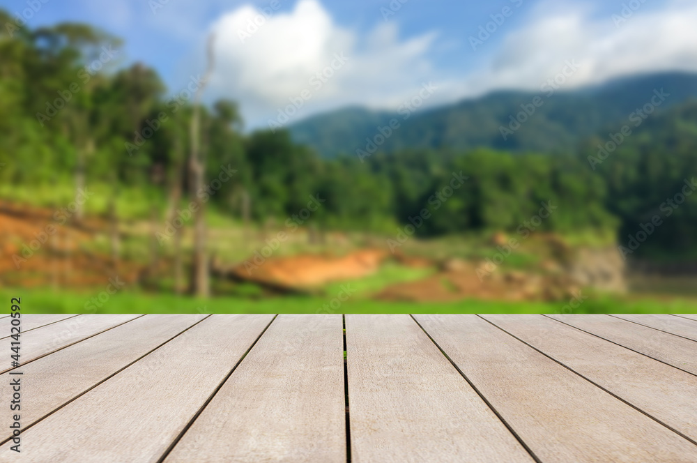 Empty old wooden table in front of blurred background of mountain, blue sky, cloud among bright sunlight on a clear day. Can be used for display or montage for show your products. Empty old wooden table in front of blurred background of mountain, blue sky, cloud among bright sunlight on a clear day. Can be used for display or montage for show your products.