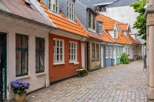 a cobblestone street and colorful small houses in the historic old city center of Aalborg