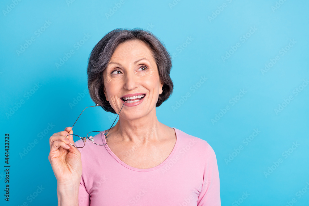 Photo of happy good mood excited dreamy woman look copyspace dreaming bite glasses isolated on blue color background Photo of happy good mood excited dreamy woman look copyspace dreaming bite glasses isolated on blue color background
