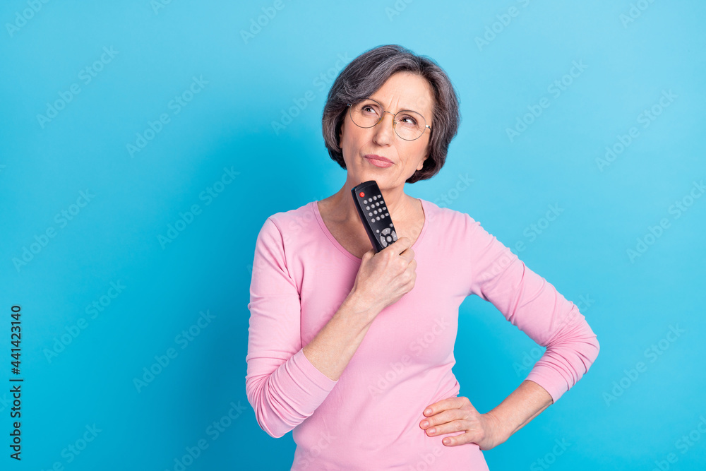 Photo of serious thoughtful minded mature woman in glasses look copyspace thinking isolated on blue color background Photo of serious thoughtful minded mature woman in glasses look copyspace thinking isolated on blue color background