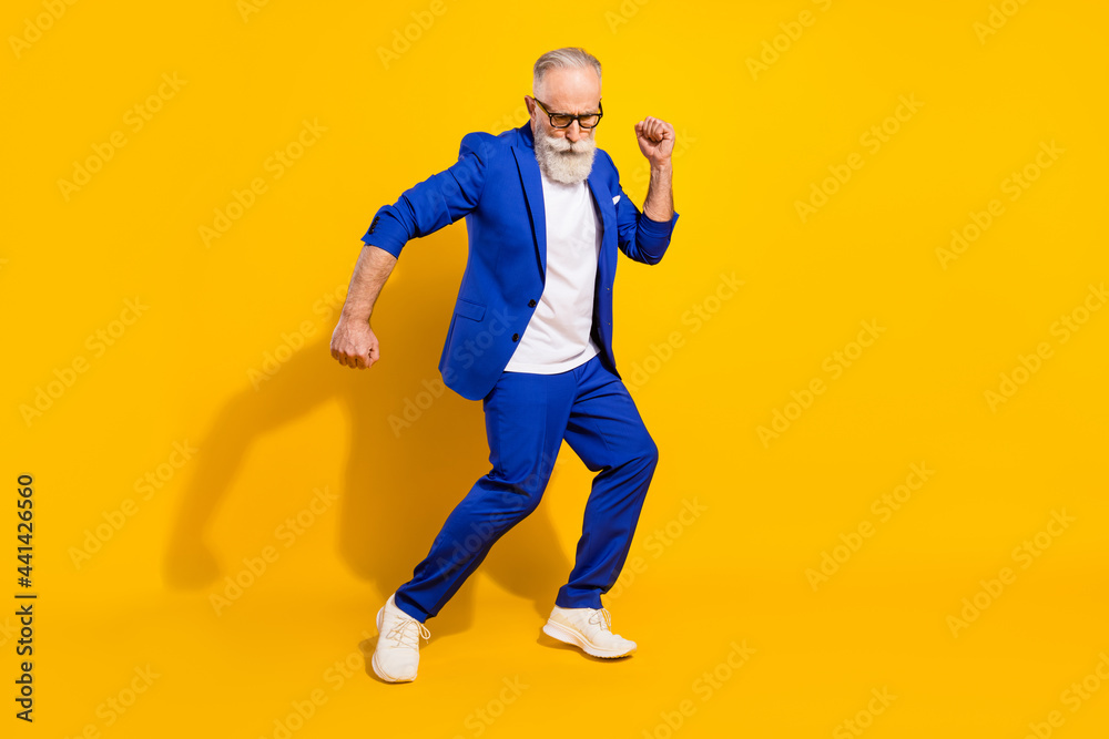 Full size photo of positive grey beard elder man dance wear spectacles blue jacket isolated on yellow background Full size photo of positive grey beard elder man dance wear spectacles blue jacket isolated on yellow background