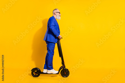 Obraz na płótnie Full size profile side photo of mature businessman riding ecological scooter iso