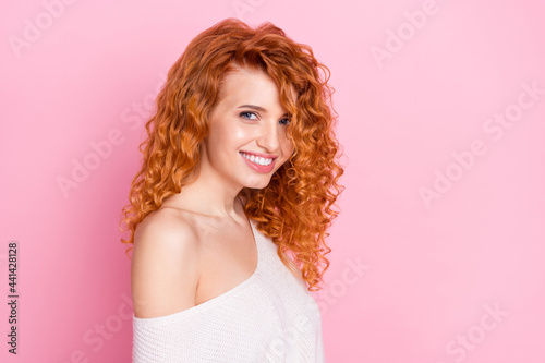 Photo portrait of red curly haired girl smiling with off-shoulder isolated on pastel pink color background copyspace