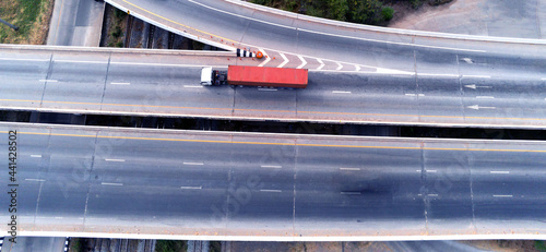 Aerial drone view of cargo white Truck on highway road with green container, transportation concept,import,export logistic industrial Transporting Land transport on the asphalt expressway