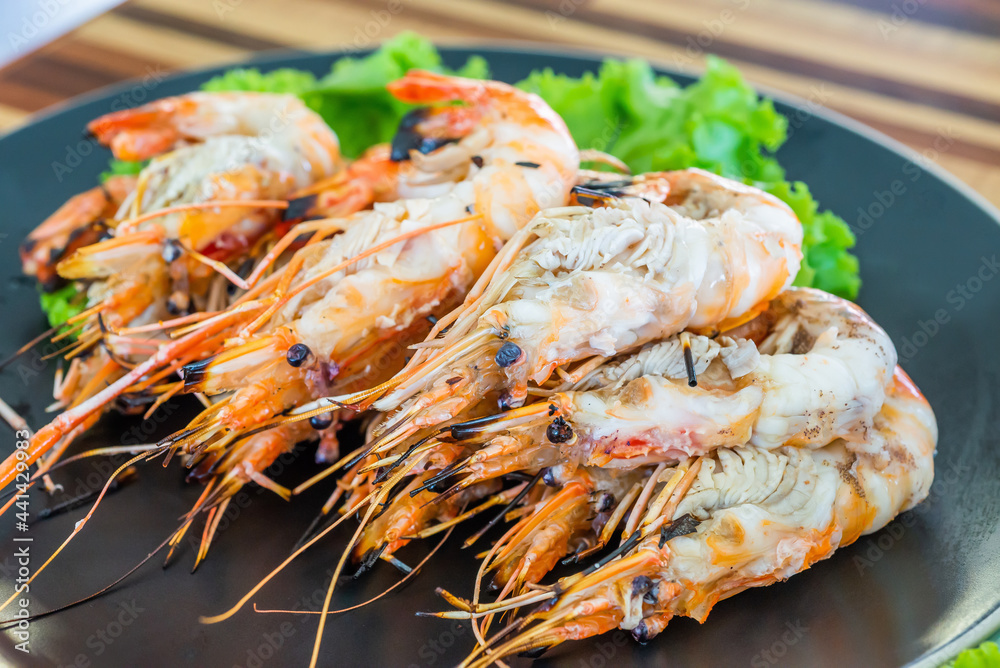 Grilled river prawn on dish. Flame grilled prawns on plates. Local food in Thailand. Regional Food Backgrounds Grilled river prawn on dish. Flame grilled prawns on plates. Local food in Thailand. Regional Food Backgrounds