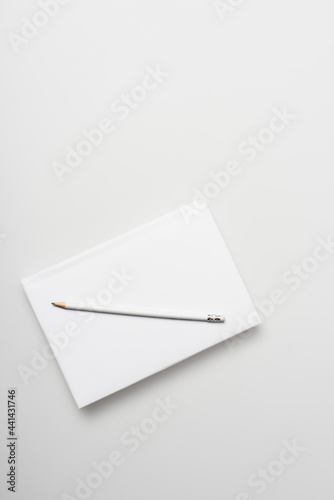 top view of notepad in hardcover with pencil isolated on white