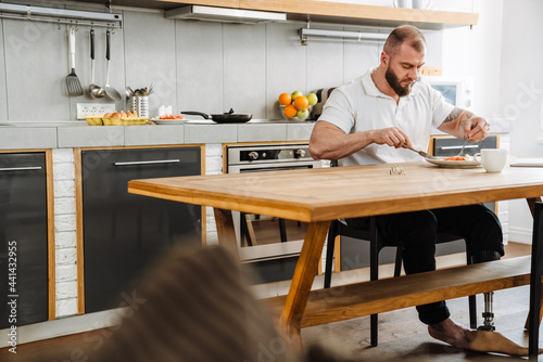 White man with prosthesis having lunch while sitting at table