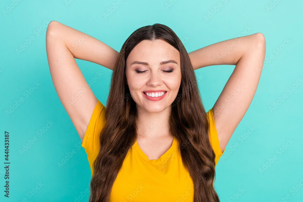 Photo of relax millennial lady hands head close eyea wear yellow t-shirt isolated on vivid teal color background Photo of relax millennial lady hands head close eyea wear yellow t-shirt isolated on vivid teal color background
