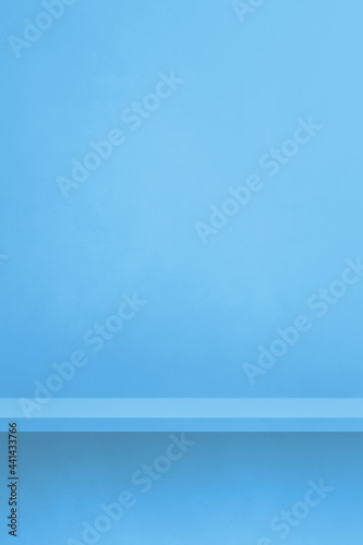 Empty shelf on a blue wall. Background template. Vertical backdrop