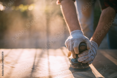 Foto A male carpenter works with a wood grinder