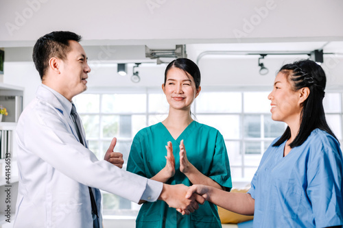 The team of medical personnel shakes hands with joy and smiles and happy expressions  the concept of success in health work young adult surgeon coworker nurse colleague cooperation